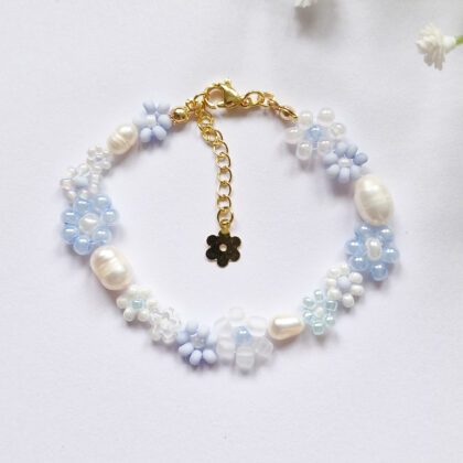 Håndlaget perlearmbånd med blomster i blått og hvitt. Seed beads, ferskvannsperler og gullforgylt lås.