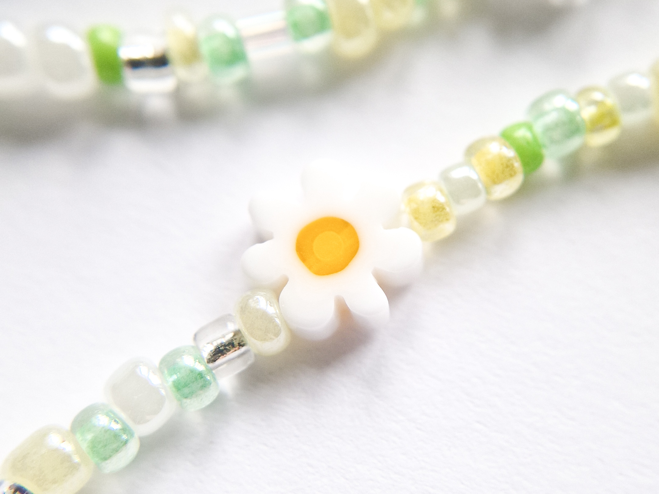 Perlesmykke i grønt med blomsterperler.