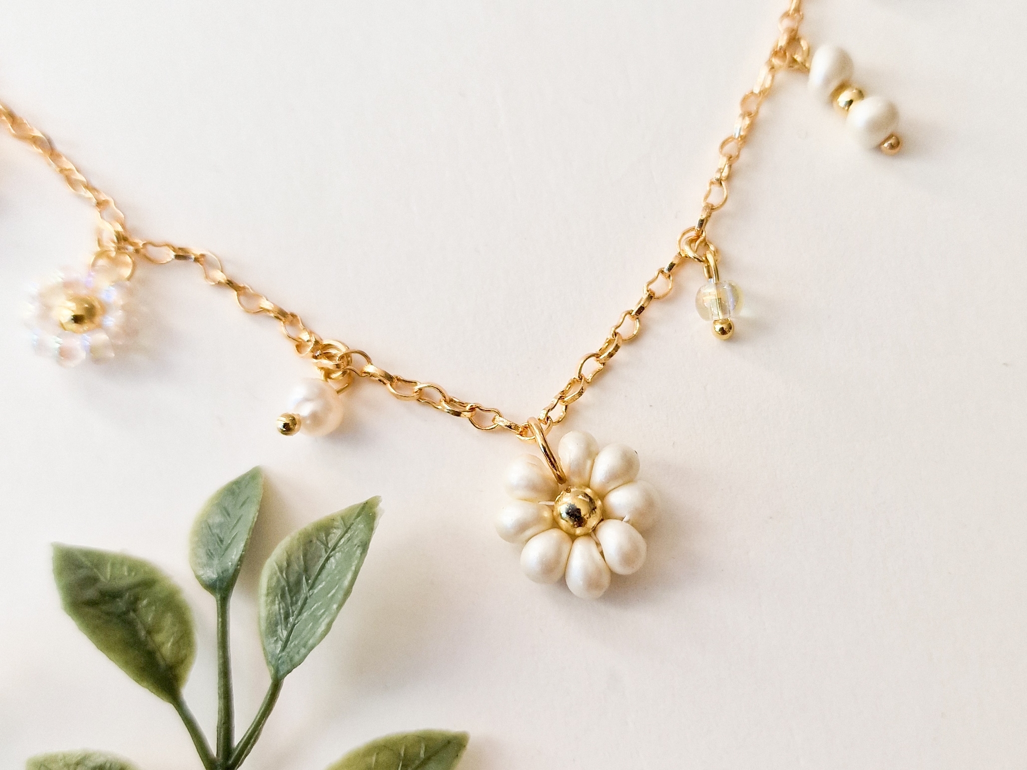 Gullforgylt smykke med blomster og perleanheng. - Bilde 2